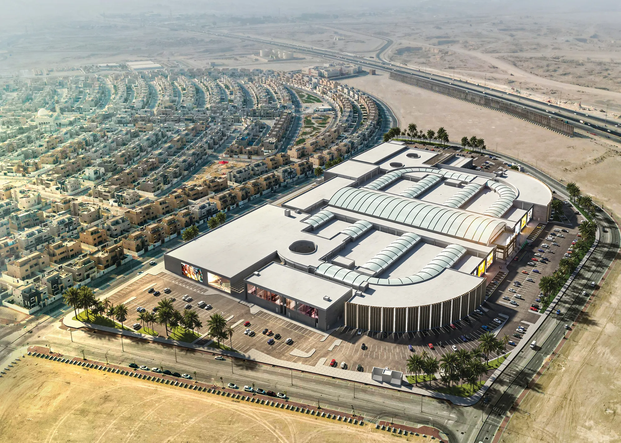 Aerial view of Ajyal Mall beside the road, with the residential district behind