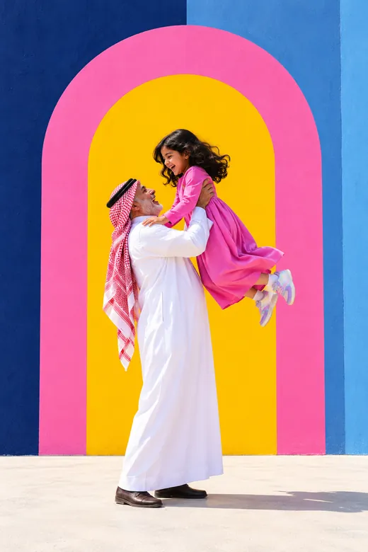 A grandfather lifting his laughing granddaughter